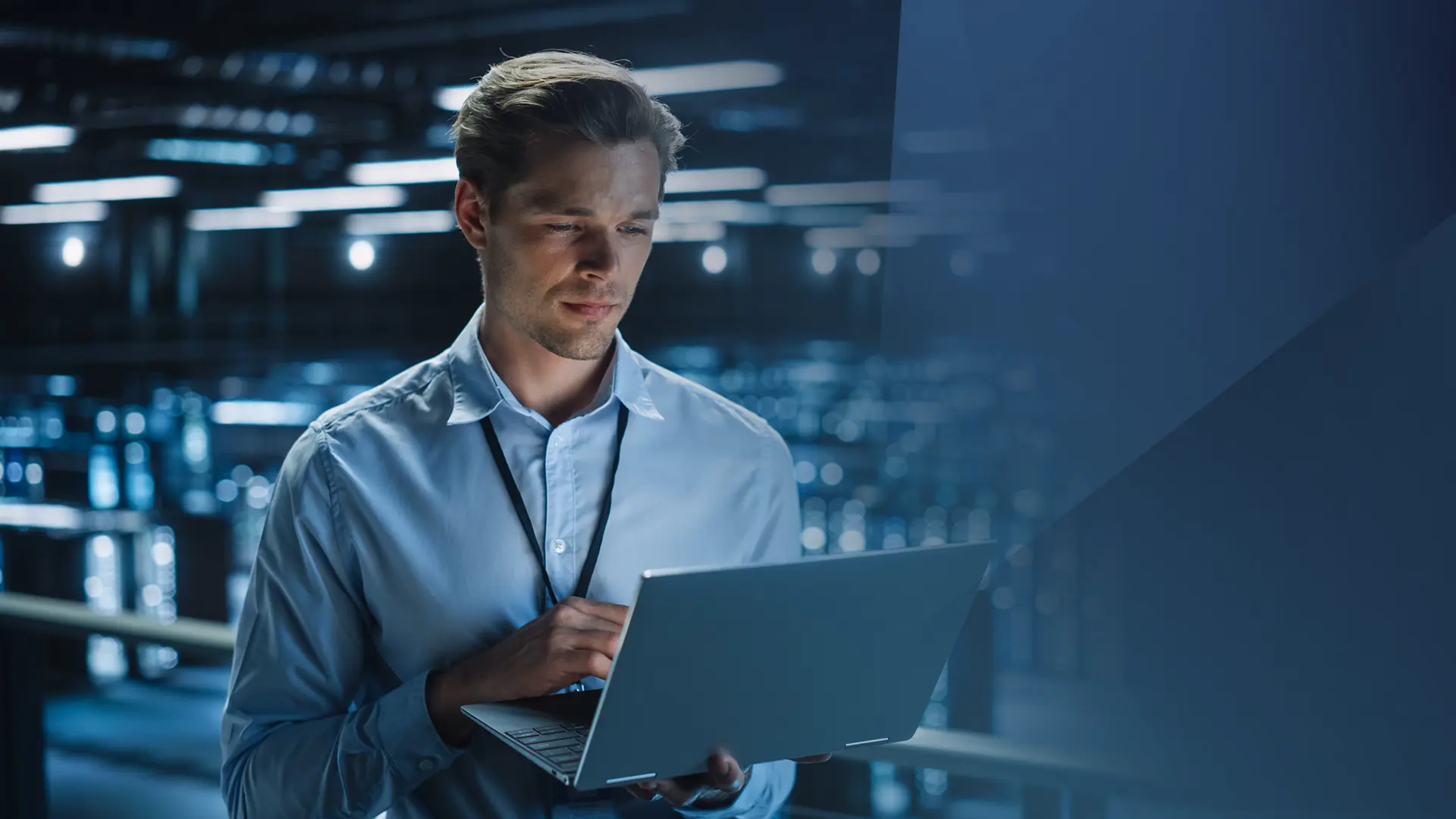 Future-X Software-Anbieter Future-X Software-Anbieter - Mann in blauem Hemd und einem offenen Laptop in der Hand