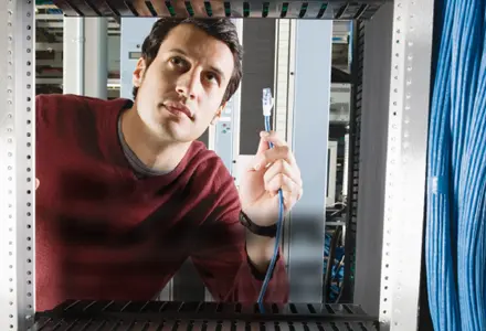 Eaton 5P USV - Die cybersichere 5P Serie. Eaton 5P USV - Die cybersichere 5P Serie. Visual junger Mann mit Netzwerkkabel in der Hand