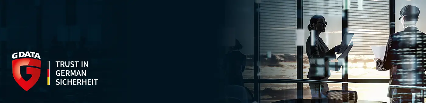 G Data entwickelt preisgekrönte IT-Sicherheitssoftware mit modernsten KI-Technologien. G Data entwickelt preisgekrönte IT-Sicherheitssoftware mit modernsten KI-Technologien. Visual 2 Personen stehen in einem Büro vor einem Fenster und das G Data Logo „Trust in German Sicherheit“ auf dunkelblauem Hintergrund ist abgebildet.