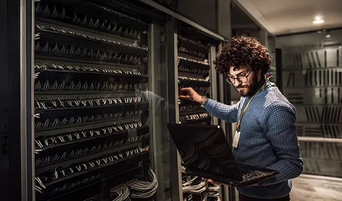 Eaton KVM-Switche ermöglichen eine effiziente Steuerung mehrerer Server von einer einzigen Konsole aus. Eaton KVM-Switche ermöglichen eine effiziente Steuerung mehrerer Server von einer einzigen Konsole aus. Foto jungen Mannes, der einen Server einrichtet.