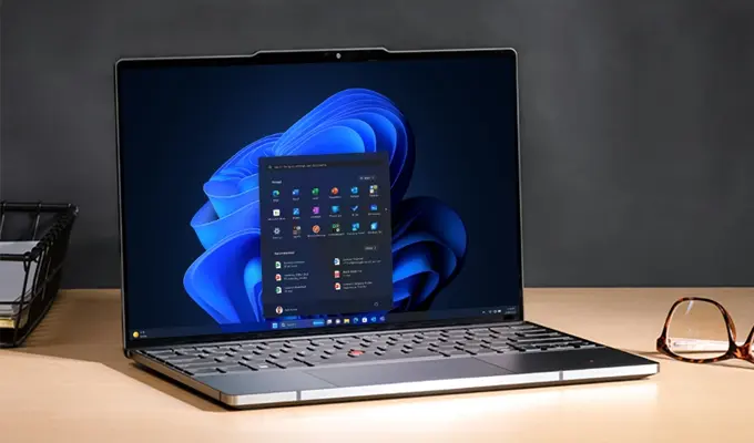 Multitasking mit Windows 11 Pro: Steigerung Ihrer Produktivität Laptop mit geöffnetem Windows 11 Pro Desktop, zeigt Startmenü und Taskleiste.