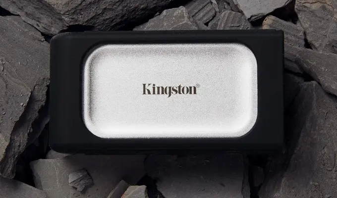 Kingston XS2000 mit Gummihülle – wasserabweisend, staubabweisend und stoßfest getestet. Kingston XS2000 mit Gummihülle – wasserabweisend, staubabweisend und stoßfest getestet. Visual der XS2000 mit Gummihülle liegt auf Steinen.