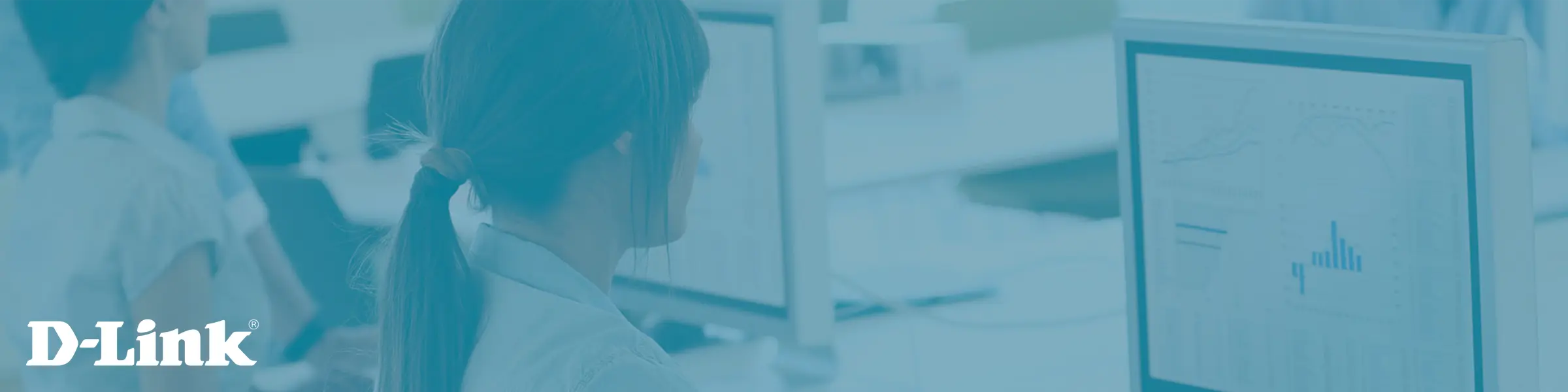 Mit der 10-Gigabit-Ethernet-Technologie erhalten Unternehmen eine stabile, leistungsfähige und zukunftssichere Basis für ihr Netzwerk. Foto aus einer Büroumgebung mit einer jungen Frau die vor einem Monitor sitzt.
