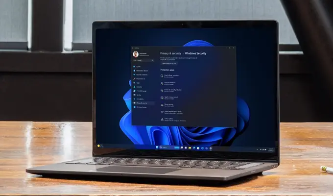 Sicher arbeiten mit Windows 11 Pro: Ein Fokus auf Datenschutz Laptop auf Schreibtisch mit aktivem Windows 11 Pro, Hervorhebung der verbesserten Sicherheitseinstellungen.
